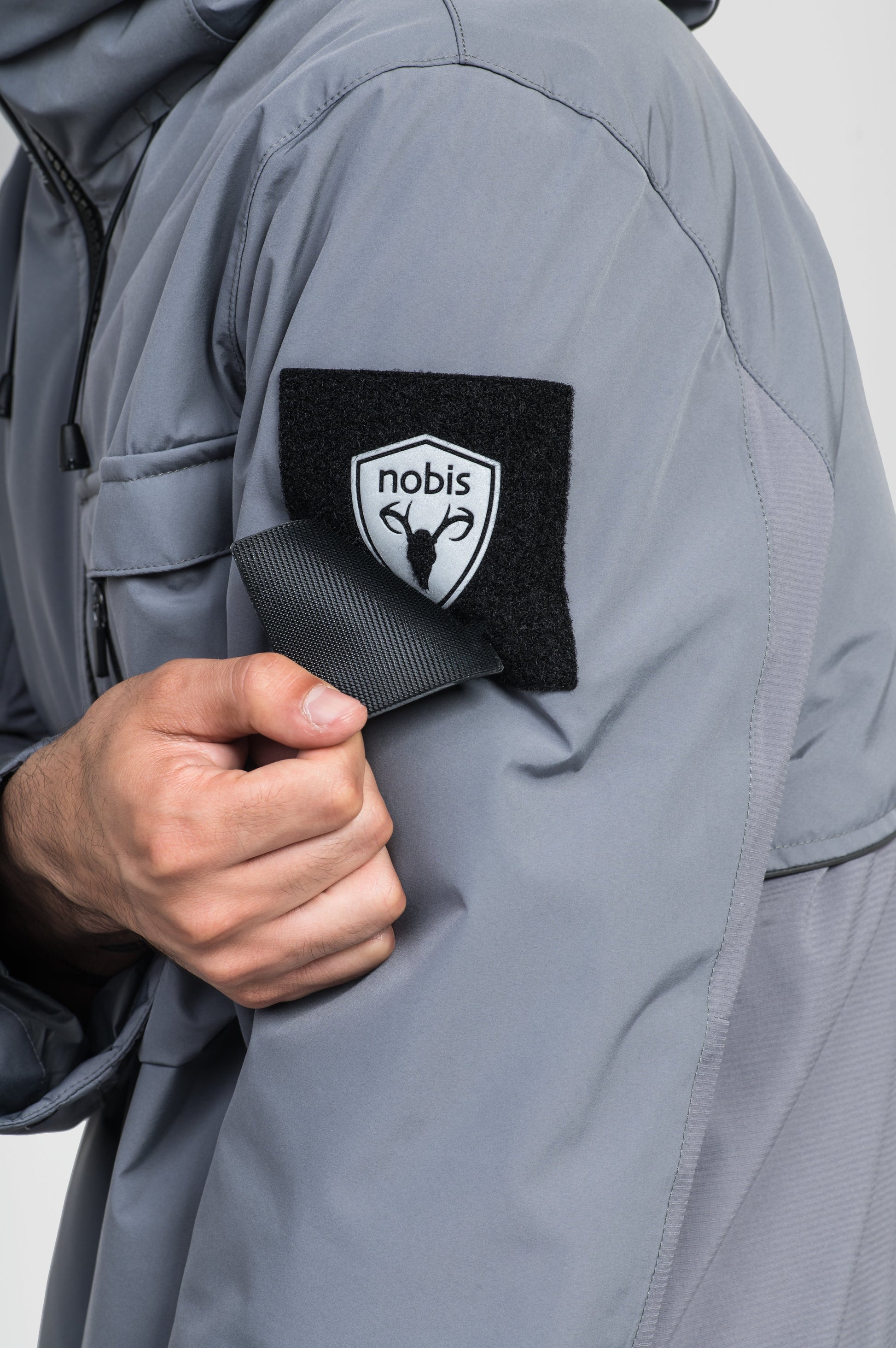 Alta Men's Performance Shell Jacket in hip length, Primaloft Gold Insulation Active+, chest and waist pockets, ventilation under arms, reflective detailing on hood and back, two-way front zipper, and non-removable hood with adjustable drawstrings, in Concrete