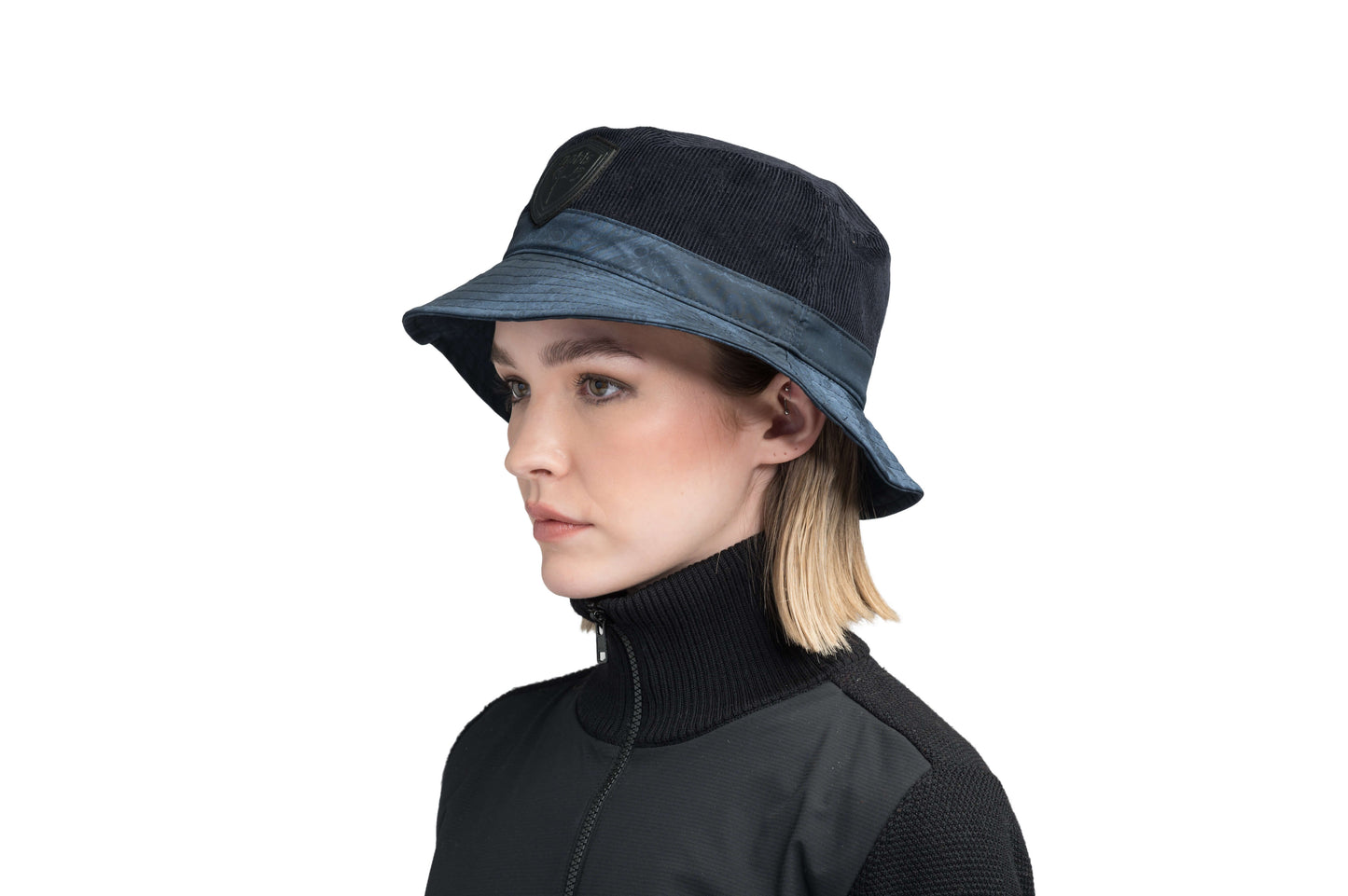 Kaia Unisex Tailored Bucket Hat in a 100% cotton corduroy and 3-ply micro denier fabrication, unstructured crown, black leather Nobis shield logo on crown front, and small flap pocket on the right side crown, in Navy