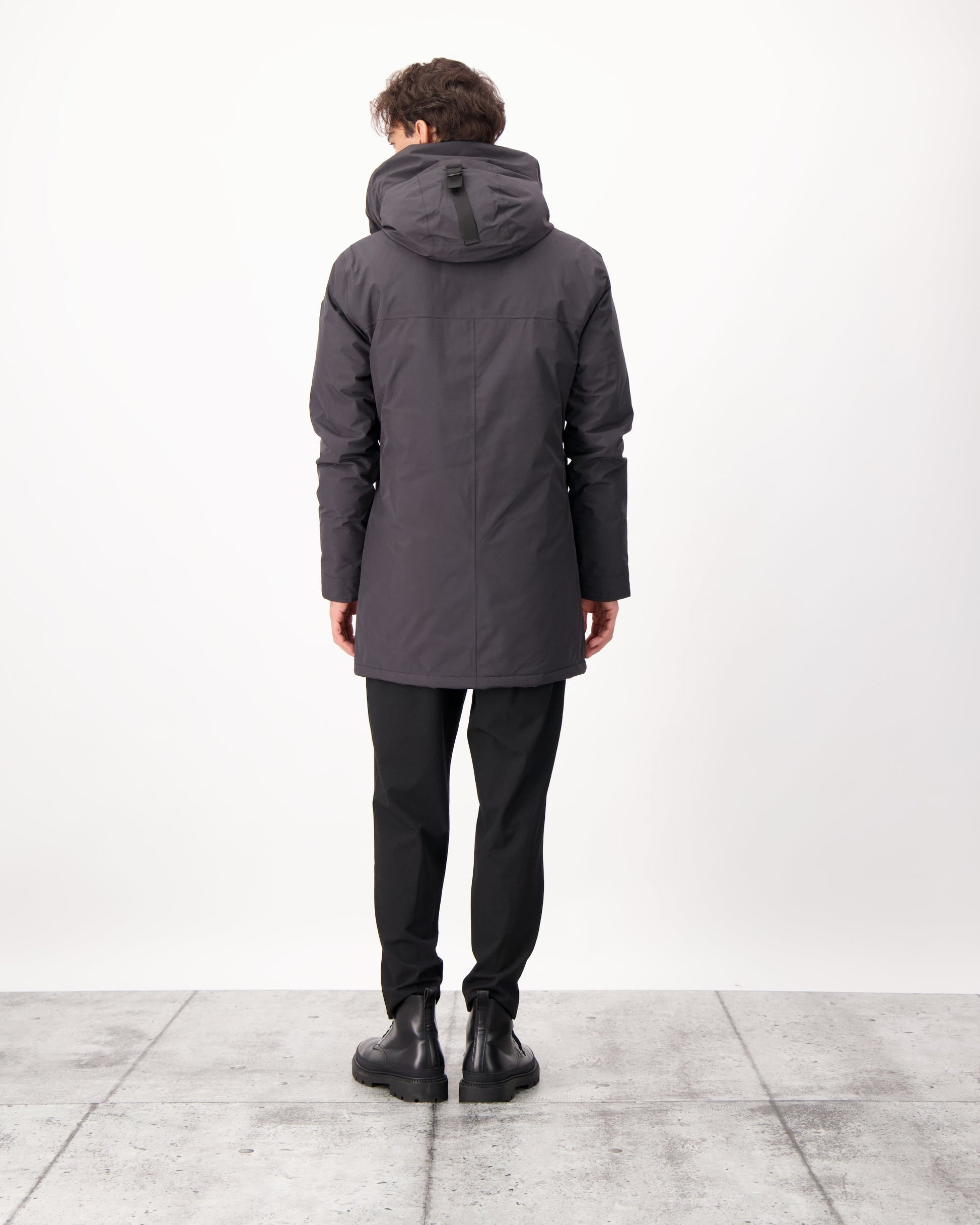 Pierre Men's Jacket in thigh length, Canadian white duck down insulation, non-removable down-filled hood, angled waist pockets, centre-front zipper with wind flap, and elastic ribbed cuffs, in 3L Black