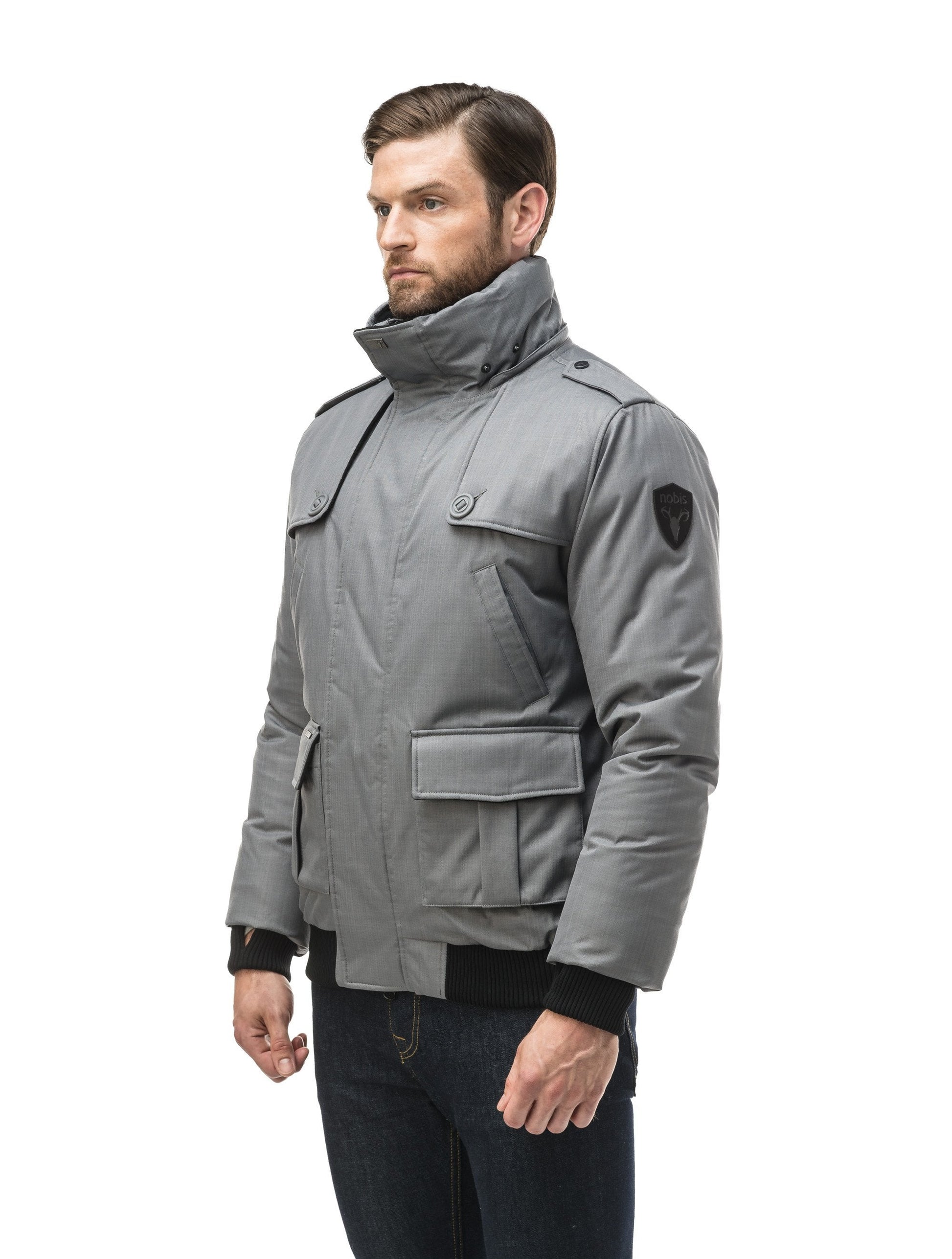 Men's down filled bomber that sits just above the hips with a completely removable hood that's windproof, waterproof, and breathable in CH Concrete