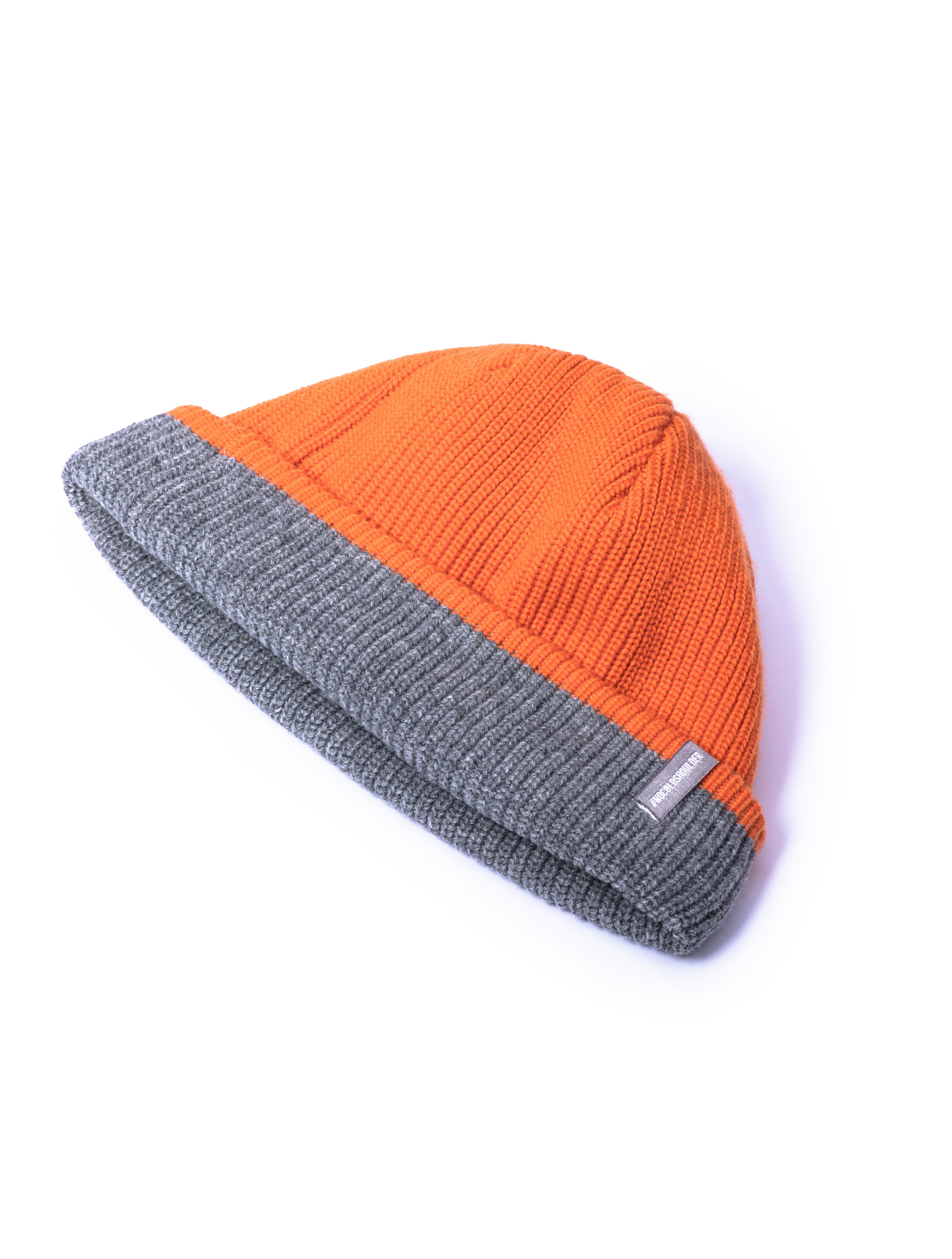 Knitted reversible beanie with orange side displayed.