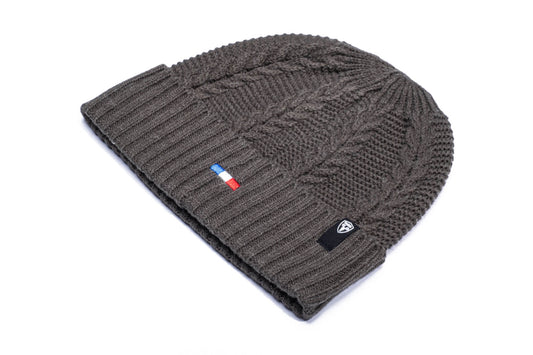 Ciryl Gane x Nobis Cable Knit Beanie with cable stitched body, gathered crown, two by two rib knit cuff, Nobis branded trim wrapped along cuff, flag of France embroidered on the cuff front, and "Bon Gamin" embroidered on the back, in H. Charcoal